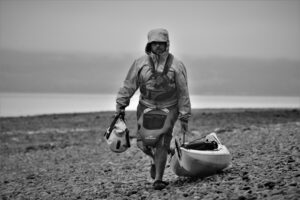 Guide Damon, walking on a beach with a kayak